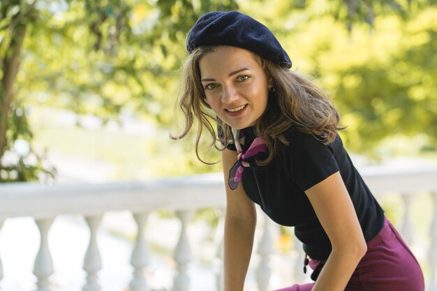 Das Mädchen in Baskenmütze und Rock im Park Nettes Mädchenporträt im französischen Stil