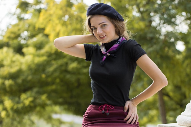 Das Mädchen in Baskenmütze und Rock im Park Nettes Mädchenporträt im französischen Stil