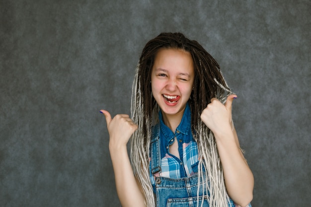 Das Mädchen in den Dreadlocks lächelt.