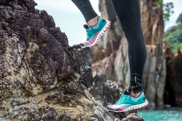 Das Mädchen in Sportbekleidung auf den Felsen