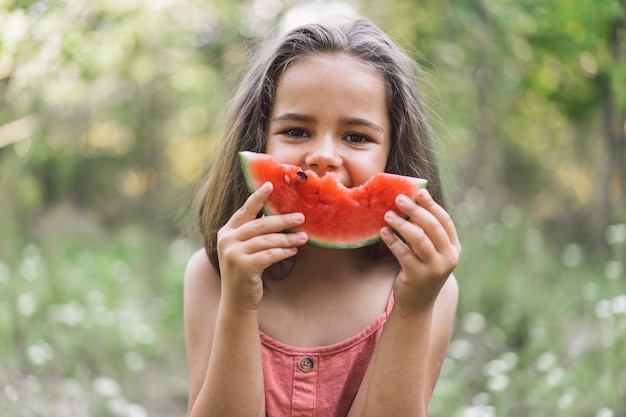 Das Mädchen isst eine Wassermelone. Sommerstimmung.
