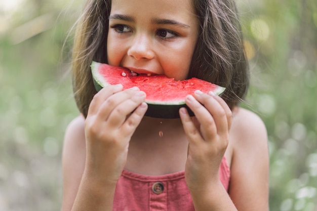 Das Mädchen isst eine Wassermelone. Sommerstimmung.