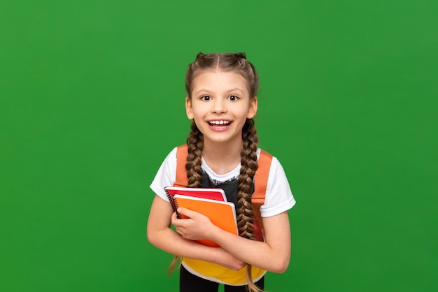 Das Mädchen ist froh, dass sie Deutsch an einer ausländischen Schule lernt Eine Schülerin mit einer deutschen Flagge auf ihrem T-Shirt und Notizbüchern in ihren Händen