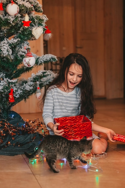 das Mädchen ist überrascht, Weihnachtsgeschenke zu öffnen