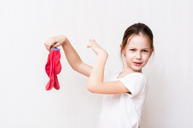 Das Mädchen kann den unangenehmen Geruch schmutziger Socken nicht ertragen