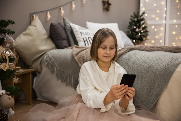 Das Mädchen kommuniziert mit dem Handy, herzlichen Glückwunsch zum neuen Jahr und Weihnachten aus der Ferne