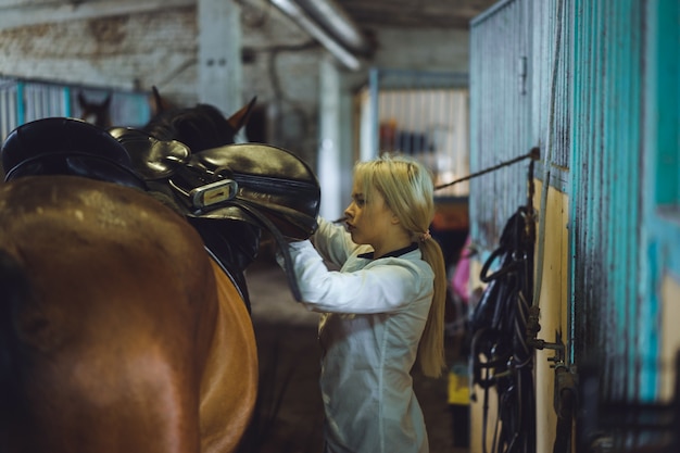 Das Mädchen kümmert sich um das Pferd