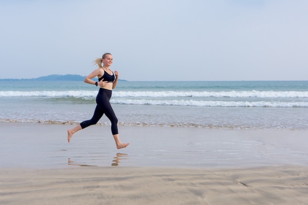 Das Mädchen läuft am Strand entlang und treibt Sport