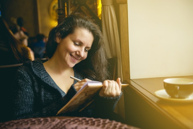 Foto das mädchen liest ein buch in einem café