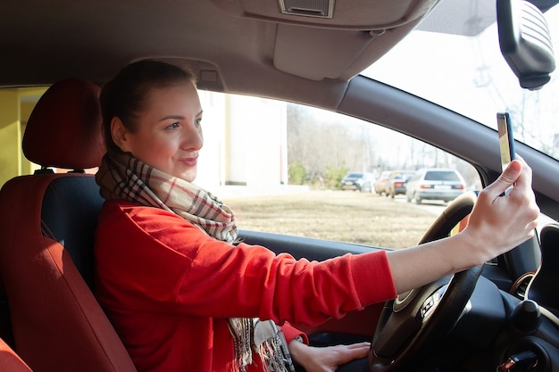 Das Mädchen macht ein Selfie im Auto