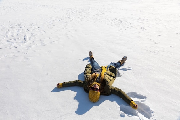 Das Mädchen macht einen Engel im Schnee