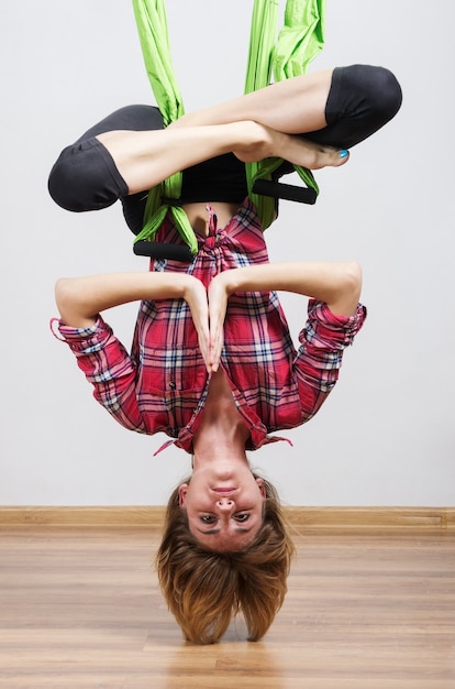 Foto das mädchen macht übungen in einer hängematte für yoga