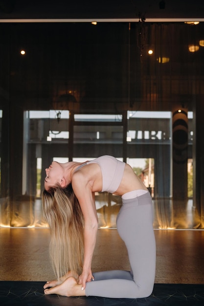 Das Mädchen macht Yoga Eine Frau in Sportkleidung macht Yoga-Übungen im Fitnessstudio