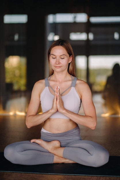 Das Mädchen macht Yoga Eine Frau in Sportkleidung macht Yoga-Übungen im Fitnessstudio