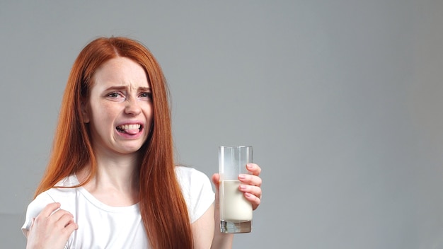 Das Mädchen mag keine Milch und sieht traurig aus für ein Glas Milch