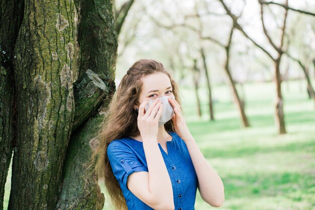 Das Mädchen mit den blauen Augen in der Maske im Blütenpark.