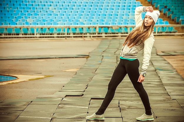 Das Mädchen rennt und treibt Sport im Stadion