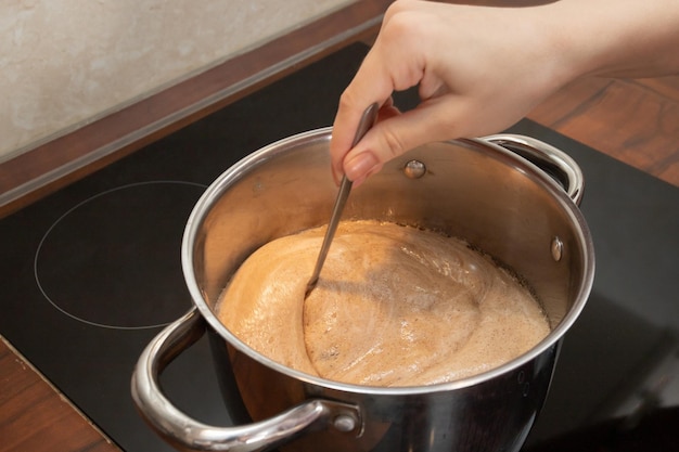 Das Mädchen rührt den Teig für Lebkuchen