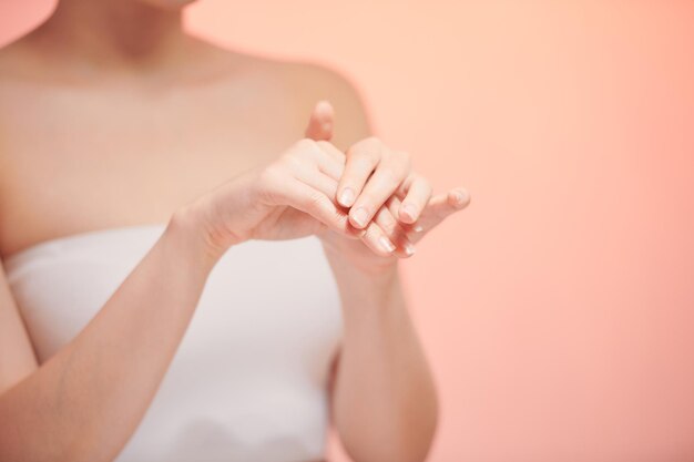 Das Mädchen schmiert die Hände mit einer kosmetischen Abgangscreme für die Jugend und Elastizität der Haut