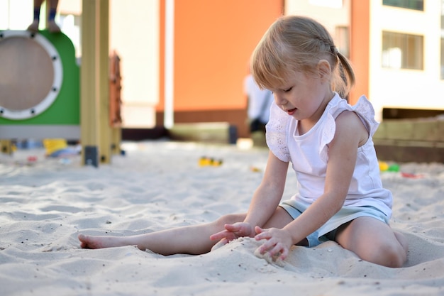 Foto das mädchen sitzt und spielt im sandkasten moderner spielplatz aktive erholung in der stadt