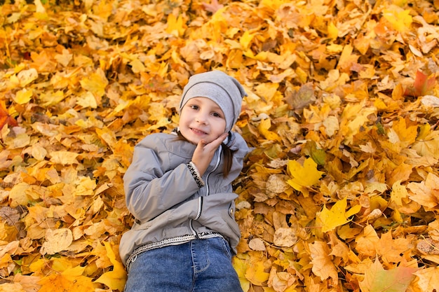 Das Mädchen spielt im Herbstlaub