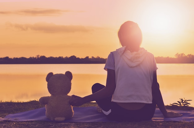 Das Mädchen spielt mit einem Teddybären.