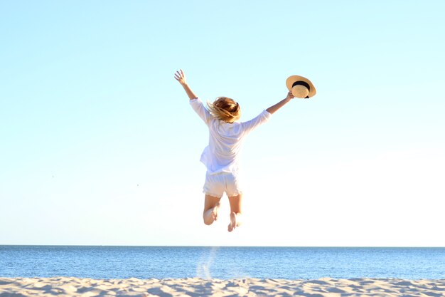 Das Mädchen springt gegen das Meer