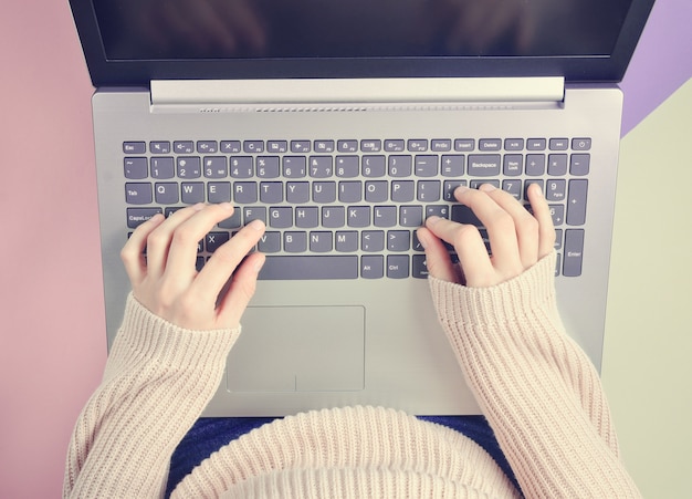 Das Mädchen tippt auf der Laptoptastatur.