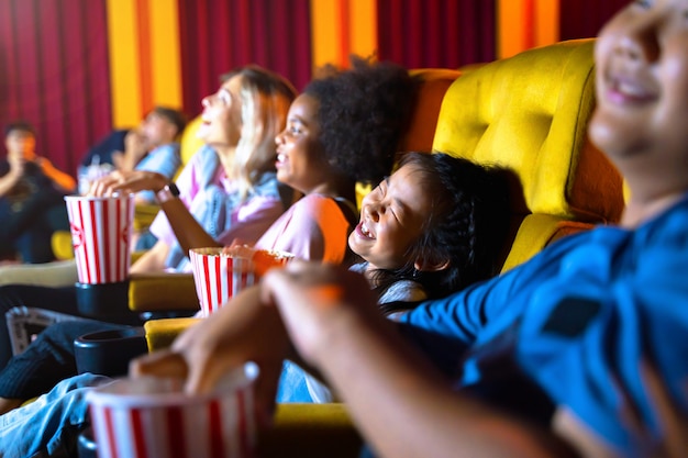 Das Mädchen und die Gruppe von Kindern sitzen und schauen im Kino zu.