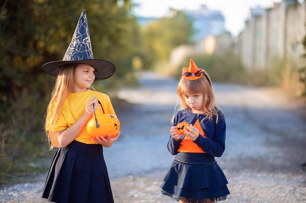 Das Mädchen war verärgert, weil sie an Halloween einen kleinen Korb mit Süßigkeiten bekommen hatte. Ein Mädchen neckt ein anderes