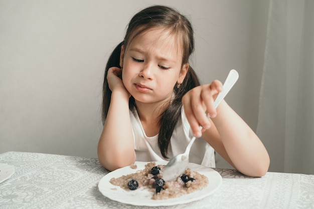 Das Mädchen will keinen Brei essen. launisch und weigert sich zu essen.