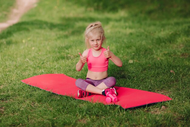 Das Mädchen zeigt einen Finger nach oben Fitness im Freien ist großartig