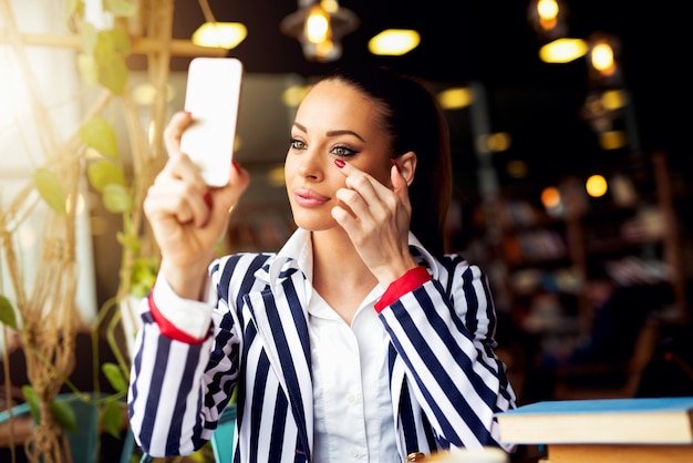 Das Make-up an der Cafe-Bar anpassen und den Spiegel betrachten.