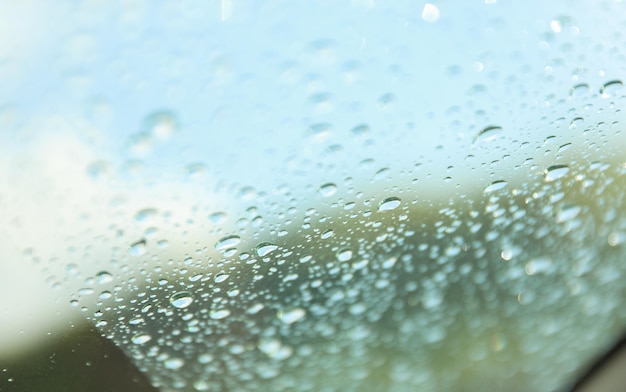 Das mit Regentropfen bedeckte Autofenster symbolisiert die Schönheit und Ruhe der Natur.