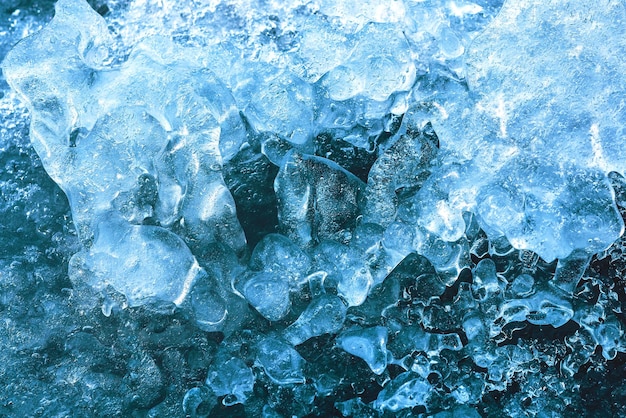 Das Muster und die Textur von blauem Eis auf einem zugefrorenen Fluss Natureishintergrund