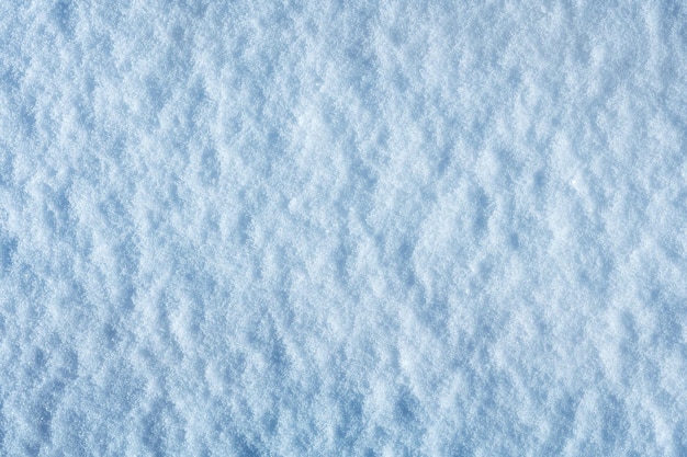 Das Muster und die Textur von frisch gefallenem Schnee an einem sonnigen Tag Naturschneehintergrund