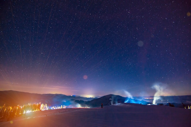 Das nachts beleuchtete Skigebiet des Resorts befindet sich an einem malerischen Ort über einem klaren Sternenhimmel. Land-Urlaub-Konzept.