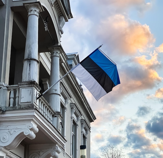 Das offizielle staatssymbol estlands ist eine flagge mit einem blau-schwarz-weißen streifen vor blauem himmel