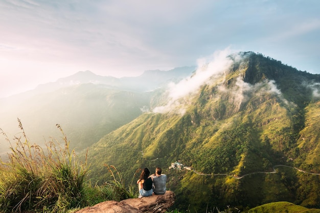 Das Paar begrüßt den Sonnenaufgang in den Bergen. Mann und Frau in den Bergen. Hochzeitsreise. Das Paar reist durch Asien. Reise nach Sri Lanka. Serpentinen in den Bergen. Leute grüßen die Morgendämmerung