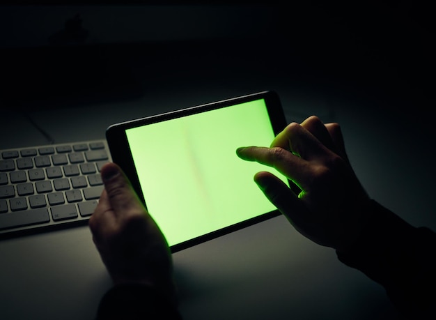 Das perfekte Display für Softwareprogramme Schnappschuss eines nicht wiederzuerkennenden Mannes, der im Dunkeln ein Tablet benutzt