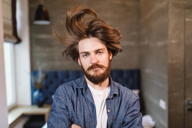 Das Porträt eines bärtigen Kerls schwang seine Haare im Schlafzimmer