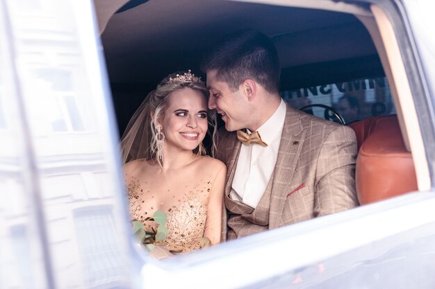 Das Porträt eines glücklichen frisch verheirateten Paares im Auto