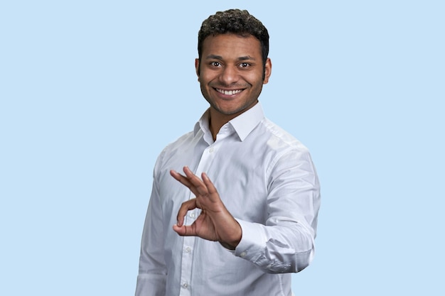 Das Porträt eines indischen jungen Mannes zeigt das OK-Gestenzeichen