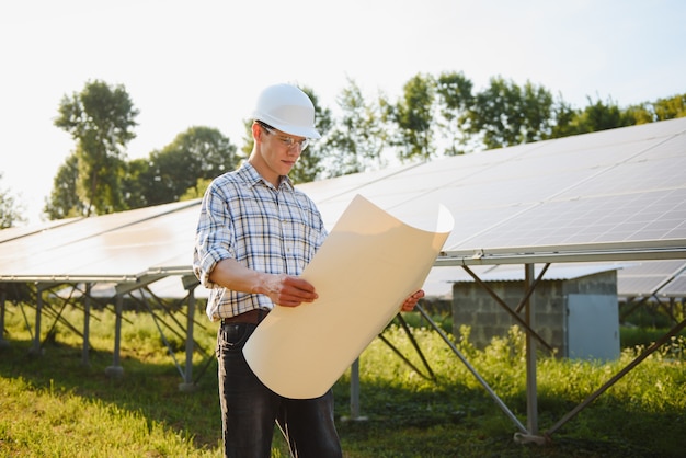 Das Porträt eines jungen Ingenieurs prüft Photovoltaik-Solarmodule