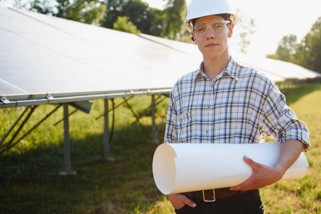 Das Porträt eines jungen Ingenieurs prüft Photovoltaik-Solarmodule