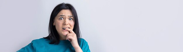 Das Porträt eines schönen Mädchens in einem blauen T-Shirt sieht mit nachdenklicher Miene beiseite und erwägt einen Plan für weitere Maßnahmen