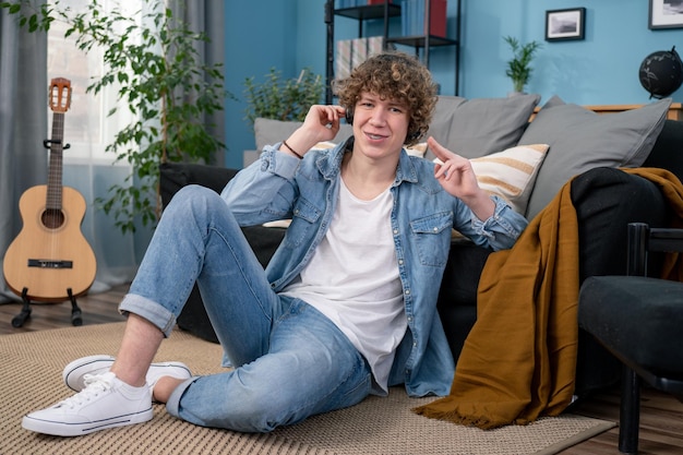 Das Porträt eines Teenager-Jungen in Jeanshose und Hemd hängt zu Hause im Wohnzimmer