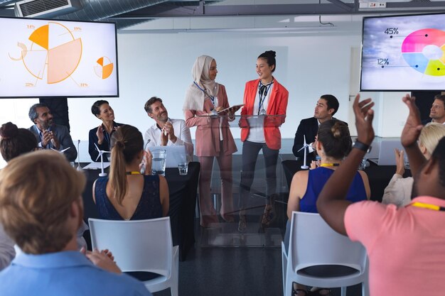 Foto das publikum applaudiert, während ein redner in einem geschäftsseminar spricht