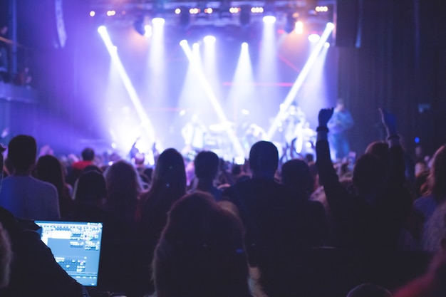 Das Publikum sieht das Konzert auf der Bühne in einem großen Konzertclub.