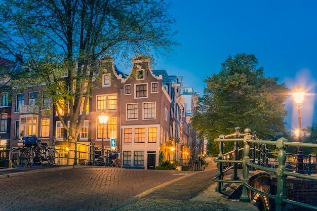 Das romantische Amsterdam beleuchtete die Lichter Abendlicher Blick auf das berühmte historische Zentrum mit Laternenlichtern, Brücken, Kanälen und niedlichen holländischen Häusern